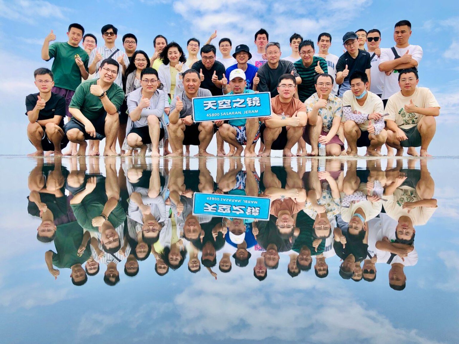 Hari-Hari group posing on the reflective shoreline at Sky Mirror