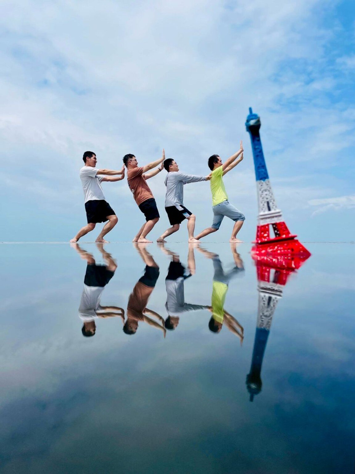 Travellers jumping for a playful perspective photo at Sky Mirror